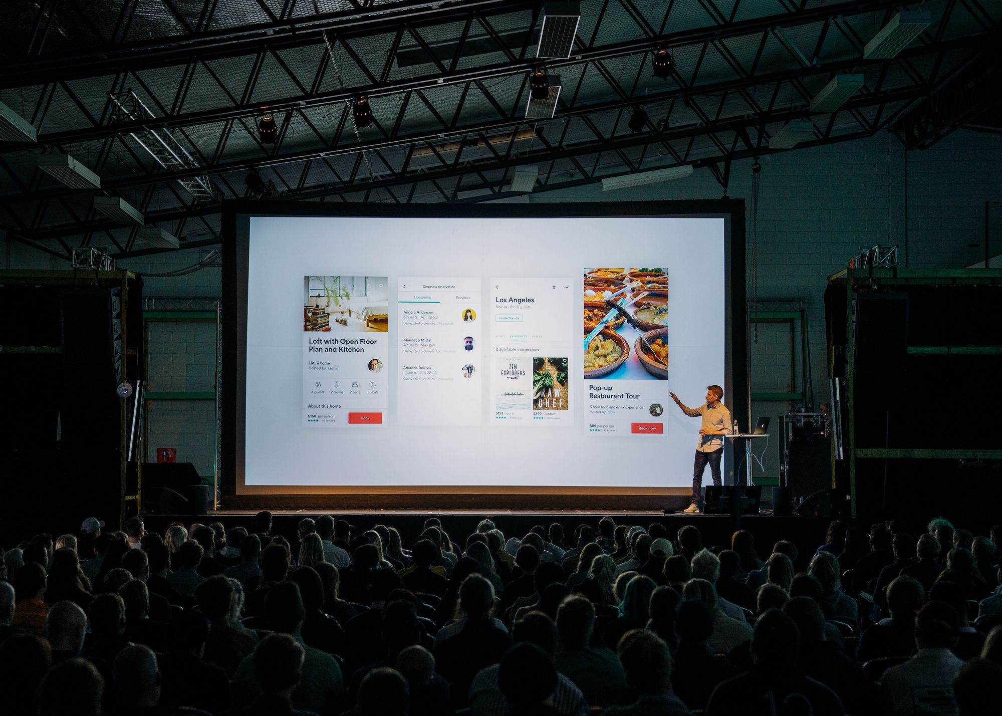 image of a man giving a presentation with a large audience.