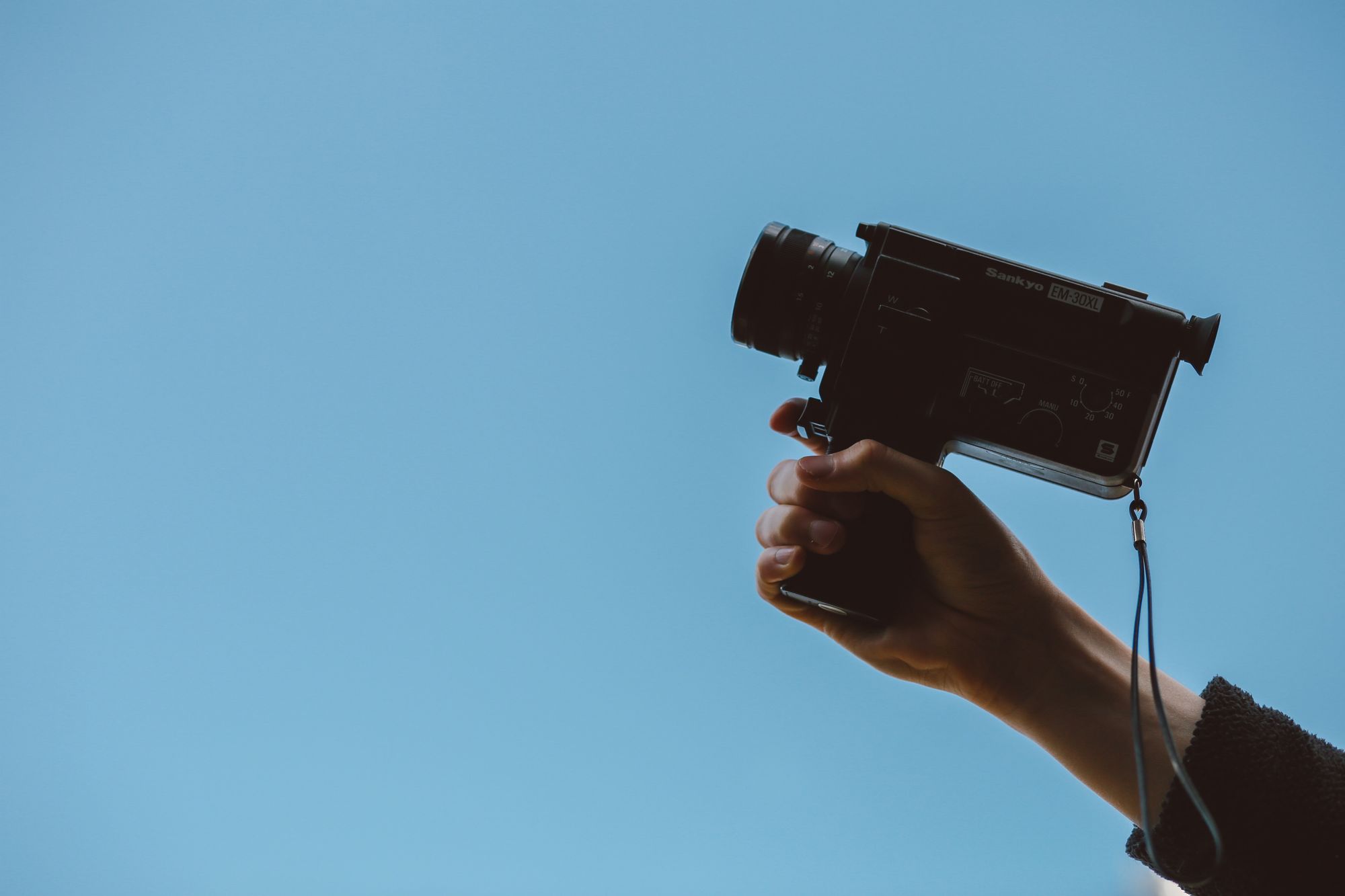 image of a hand holding up a small video recorder