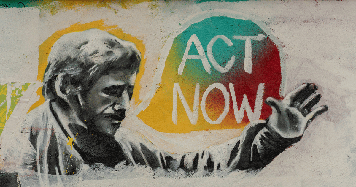 Street art of a man in black and grey with a speech bubble reading "Act now".